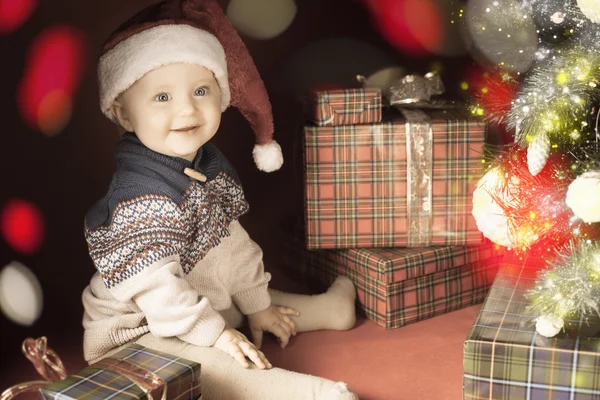 Χριστούγεννα μωρό κάθονται κοντά το χριστουγεννιάτικο δέντρο και δώρου! — Φωτογραφία Αρχείου