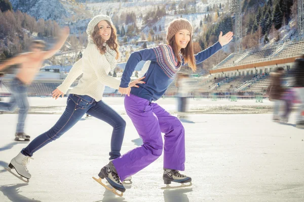 Grupo divertido adolescentes patinaje sobre hielo al aire libre en pista de hielo —  Fotos de Stock