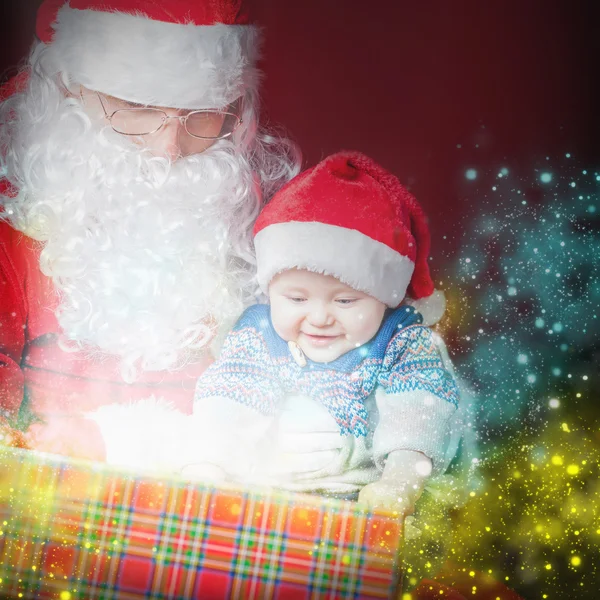 Natal bebê e Papai Noel abrindo um presente ou caixa de presente — Fotografia de Stock