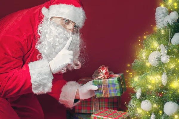 Santa Claus poner caja de regalo o regalo bajo el árbol de Navidad — Foto de Stock