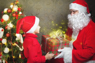 Mutlu çocuk ve Noel Baba ile büyük hediye kutusu