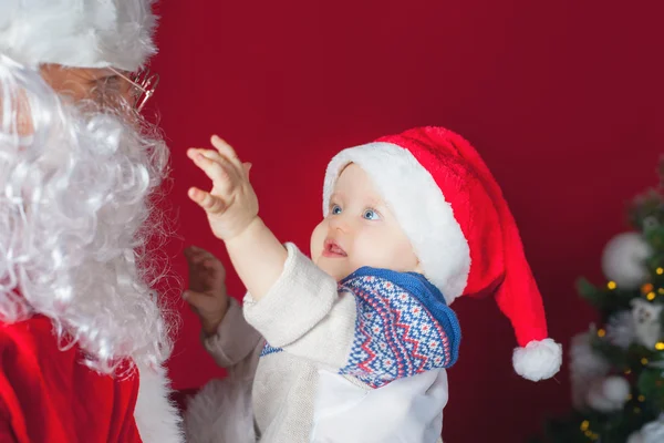 Closeup bebê feliz e Papai Noel à espera de presente, presente . — Fotografia de Stock