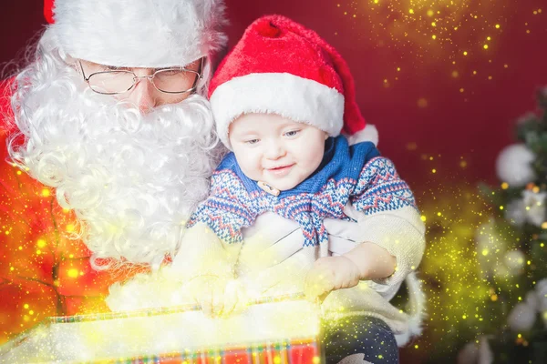 Natal bebê e Papai Noel abrindo um presente ou caixa de presente — Fotografia de Stock