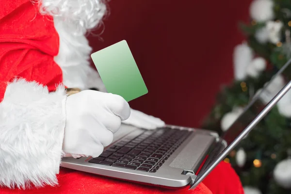 Santa compra con tarjeta de plástico Regalo de Navidad en Internet — Foto de Stock