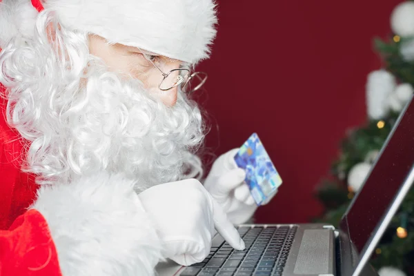 Santa compra por cartão de plástico presente de Natal na Internet — Fotografia de Stock