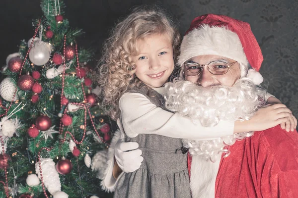 Kislány ölelést Mikulás karácsony éjjel — Stock Fotó