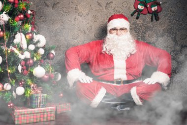 Noel arifesi gece Noel ağacının yanında oturan