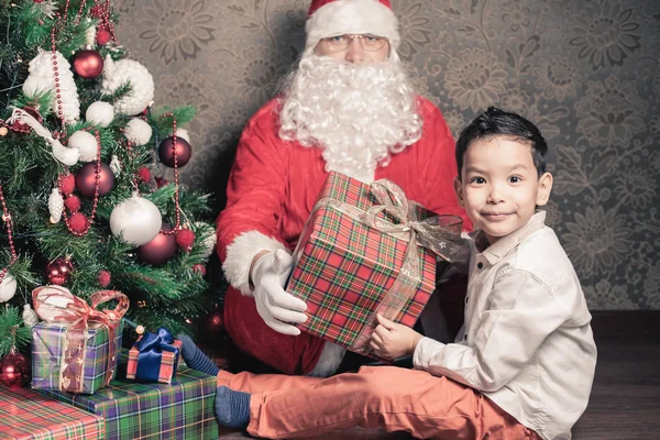 Menino multirracial feliz e Papai Noel com grande caixa de presente — Fotografia de Stock