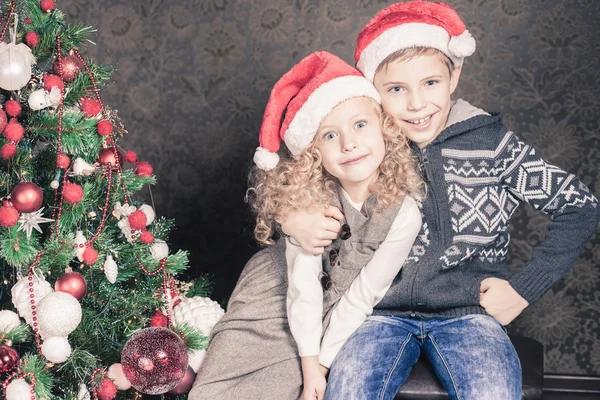 Crianças felizes no feriado de Natal perto da árvore de Natal decorada — Fotografia de Stock