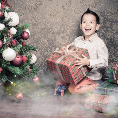 Noel'de bir büyük hediye kutusu tutarak mutlu multiraceal çocuk