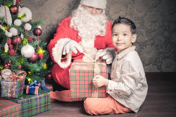 Multiraceal ευτυχισμένο αγόρι και ο Άγιος Βασίλης με μεγάλο δώρο πλαίσιο — Φωτογραφία Αρχείου