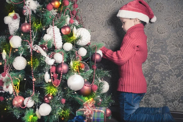 Rapaz feliz a decorar uma árvore de Natal — Fotografia de Stock