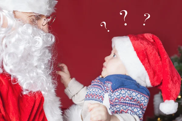 Bebé sorprendido mirando a Santa Claus, esperando un regalo —  Fotos de Stock