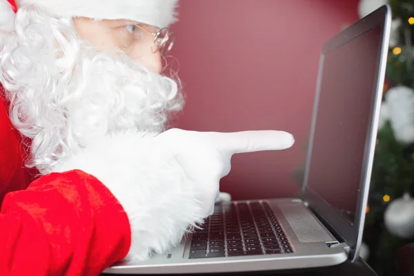 Papai Noel usando computador portátil, apontando para a tela — Fotografia de Stock