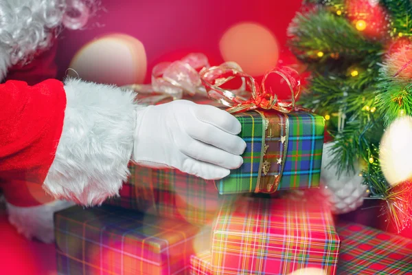 Luz de Navidad e inspiración con Santa Claus poniendo caja de regalo — Foto de Stock