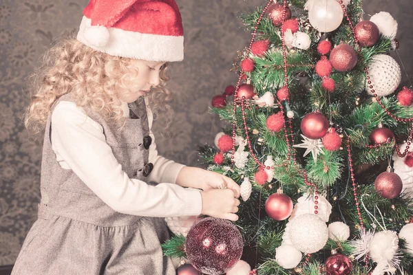 Menina feliz decorar uma árvore de Natal — Fotografia de Stock