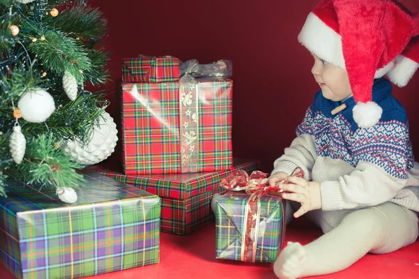 Gelukkig baby met vele doos van de gift in de buurt van gedecoreerde kerstboom — Stockfoto