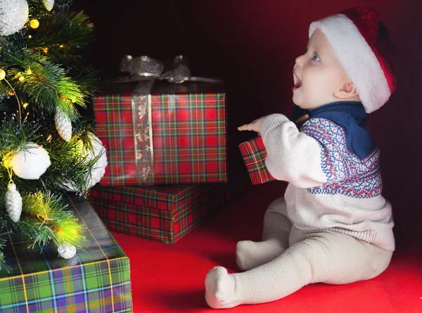 Boldog baba közelében díszített karácsonyfa és sok ajándék doboz — Stock Fotó