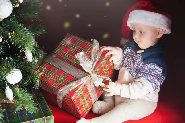 Διακοπές των Χριστουγέννων. Μωρό στο πλαίσιο Άνοιγμα καπέλο Santa δώρα — Φωτογραφία Αρχείου