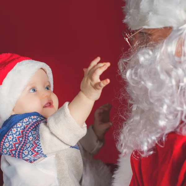 Closeup bebê feliz e Papai Noel à espera de presente, presente . — Fotografia de Stock