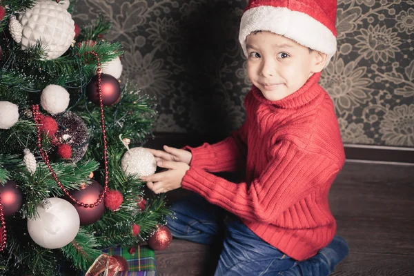 Rapaz feliz a decorar uma árvore de Natal — Fotografia de Stock