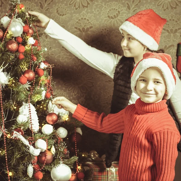Criança feliz, menino e menina decorando uma árvore de Natal — Fotografia de Stock