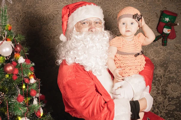 Papai Noel segurando bebê perto da árvore de Natal — Fotografia de Stock