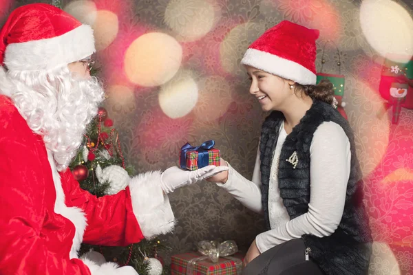 Menina feliz e Papai Noel com caixa de presente — Fotografia de Stock