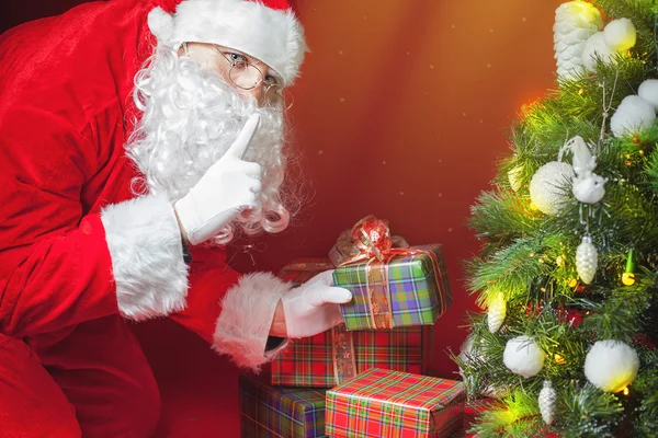 Santa Claus stawianie pudełko lub prezent pod choinkę — Zdjęcie stockowe