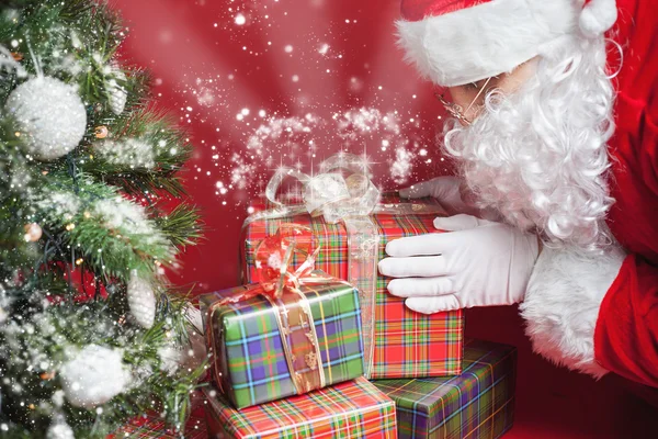 Papai Noel colocando caixa de presente ou presente sob a árvore de Natal — Fotografia de Stock