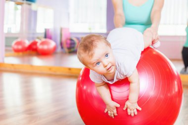 Jimnastik topu ile egzersizleri yapıyor mutlu bebek ile anne