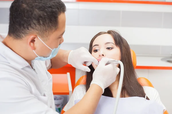 Врач-дантист лечит пациентку с зубами в стоматологическом кабинете — стоковое фото