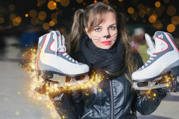 Pretty woman dressed in cat fancy dress holding skates shoes — Stock Photo, Image