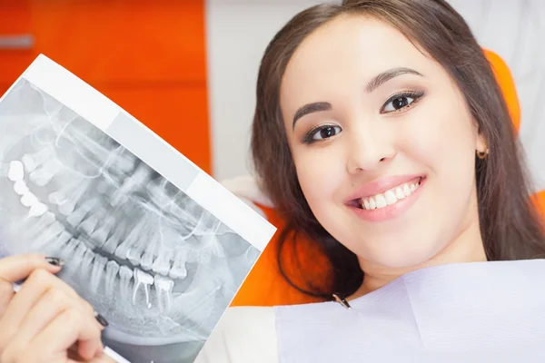 Пацієнтка красива дівчина тримає рентгенівське зображення зубів — стокове фото