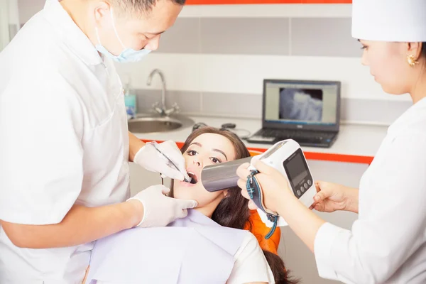 Médico dentista haciendo tratamiento dental y usando una computadora de rayos X — Foto de Stock