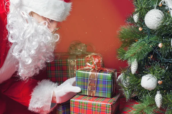 Papai Noel colocando caixa de presente ou presente sob a árvore de Natal — Fotografia de Stock