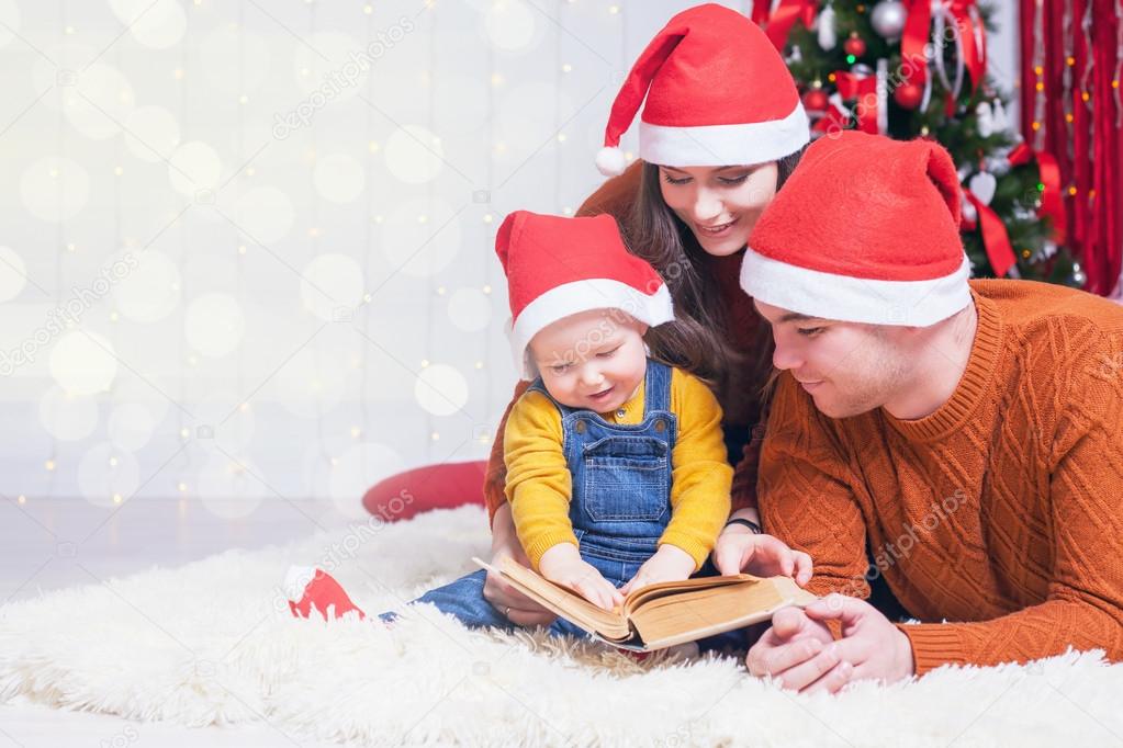 Happy family reading a book with christmas fairy tale 