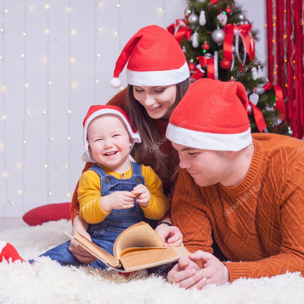 Happy family reading a book with christmas fairy tale 