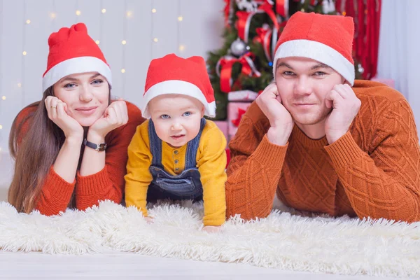 Lycklig familj på julafton sitter tillsammans nära dekorerade träd — Stockfoto