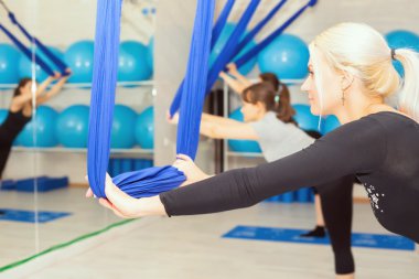 Olgun kadın hava yoga egzersiz veya antigravity yoga yaparken
