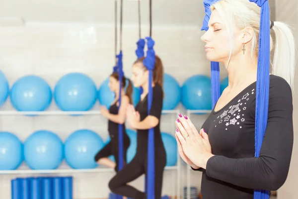 Mujeres jóvenes haciendo ejercicio de yoga aéreo o yoga antigravedad —  Fotos de Stock