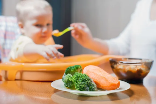 Mamá alimenta la sopa de bebé. Alimento para bebés saludable y natural — Foto de Stock