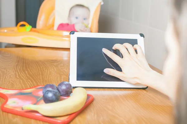 Mutter sucht Rezept für die Zubereitung von Babynahrung — Stockfoto