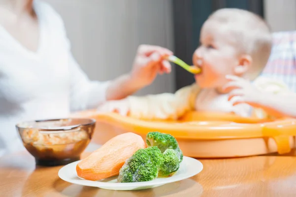 Mamá alimenta la sopa de bebé. Alimento para bebés saludable y natural — Foto de Stock