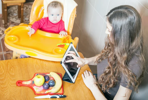 Mutter sucht Rezept für die Zubereitung von Babynahrung — Stockfoto