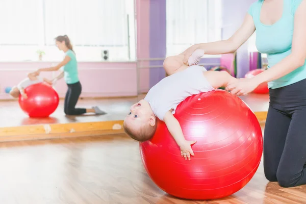 Mor med happy baby göra övningar med gymnastik boll — Stockfoto