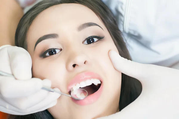 Médico dentista trata dentes paciente menina no consultório odontológico — Fotografia de Stock