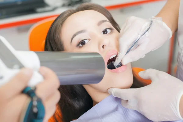 Médico dentista haciendo tratamiento dental y usando una computadora de rayos X — Foto de Stock