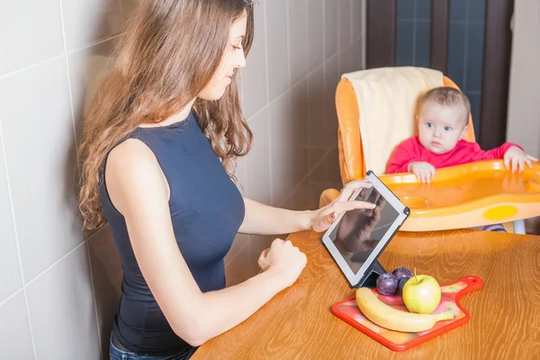 Mãe procurando receita de preparação de comida de bebê — Fotografia de Stock