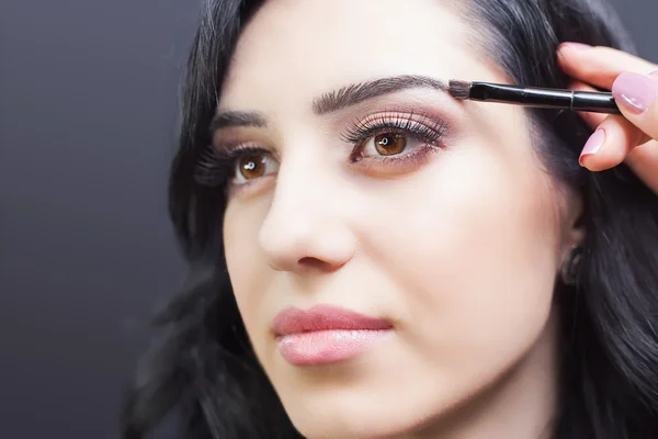 Beautiful woman at beauty salon receives makeup — Stock Photo, Image